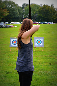 woman shots target using bow during daytime thumbnail