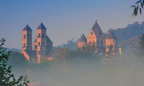 brown castle surrounded by mist thumbnail