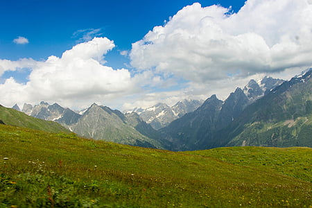green grass field overlooking mountains during daytime thumbnail
