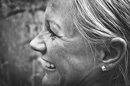 garyscale photo of woman wearing silver-colored earrings thumbnail