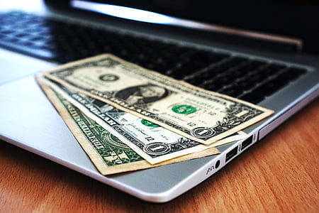 three 1 U.S. dollar banknotes on MacBook Pro thumbnail