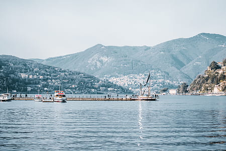 calm body of water on dock with mountain background thumbnail