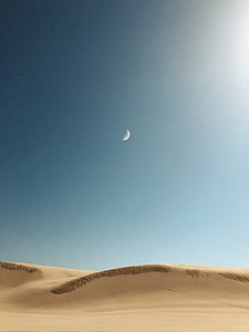 crescent moon photo in desert during daytime thumbnail