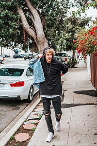 man walking on sidewalk wearing jacket thumbnail
