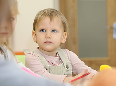 close up photo of toddler sitting on chair beside girl thumbnail