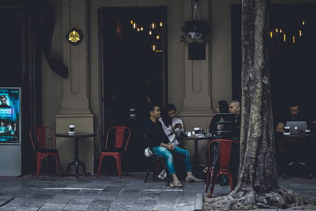people sitting next to dining table near brown wall thumbnail