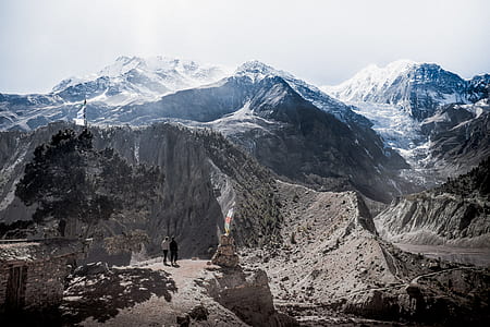 two person on brown soil in distance glacier mountain thumbnail