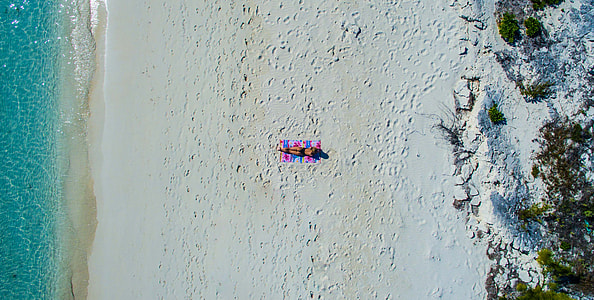 aerial photo of person lying on seashore during daytime thumbnail