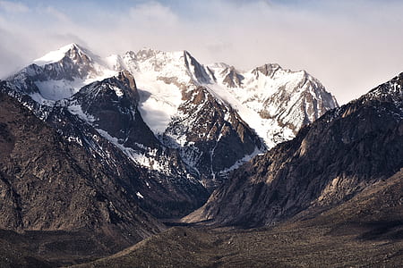 snow capped mountain under white clouds during daytime thumbnail