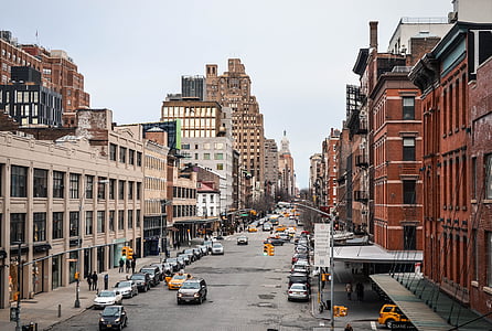 brown and beige concrete buildings between cars on street thumbnail
