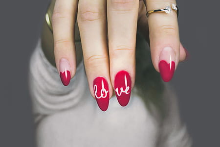 woman showing red manicure with love sign thumbnail