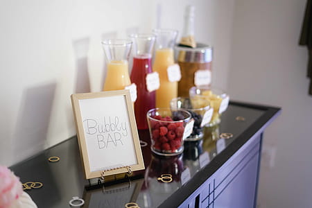 Bubbly Bar Sign With Several Assorted-color Liquid With Bottles on Top of Black Wooden Table thumbnail