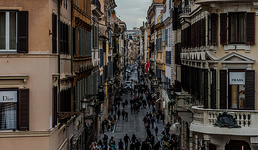 people walking on road in middle of buildings thumbnail