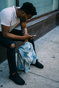 man seating on side holding phone thumbnail