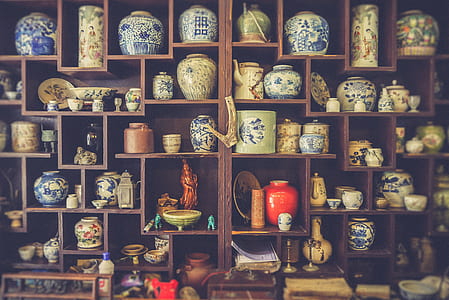assorted-color ceramic vases on brown wooden wall-mount shelf thumbnail