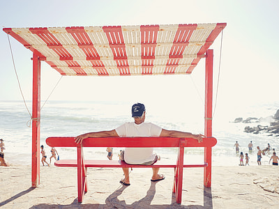 man wearing shirt sitting on red wooden bench thumbnail