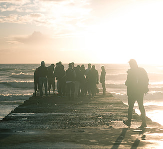 photo of group of people stand on bride during daytime thumbnail