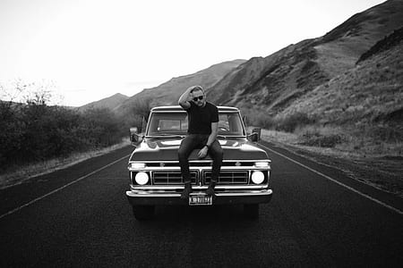 man sitting on classic truck hood thumbnail