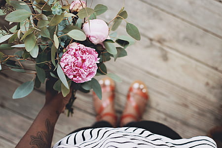 selective focus photo of human hand holding bouquet of pink petaled flowers thumbnail