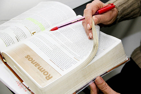 Person holding a ballpoint pen and a book thumbnail