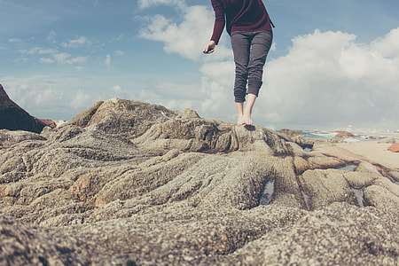 person standing on rock near shore thumbnail