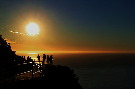 silhouette of person standing near body of water with sunlight thumbnail