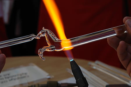 shallow focus photography of glass blower making glass horse thumbnail