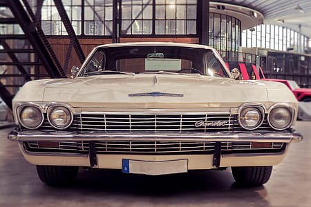 classic beige Chevrolet car parked inside building thumbnail