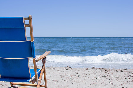 blue padded brown wooden chair at beach thumbnail