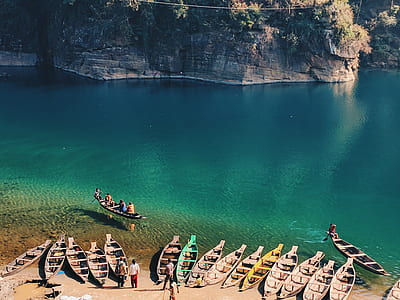 assorted-color canoe boats in seashore thumbnail
