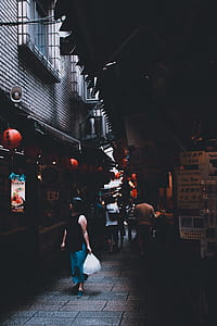person in black sleeveless top carrying white plastic bag looking at store thumbnail