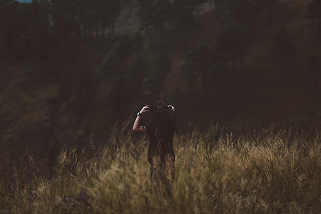 woman in black shirt standing on brown grass photo thumbnail