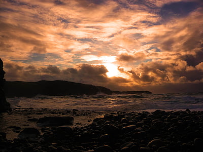 rock formation near body of water during golden hour thumbnail