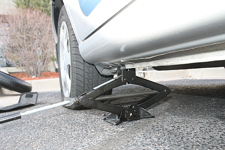gray car lifted by black scissor jack thumbnail