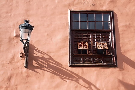 sconce lamp beside black and brown windows thumbnail