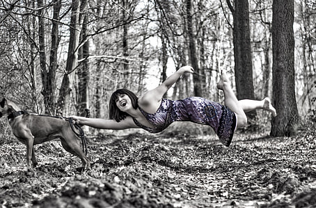 woman in purple dress holds a dog in a middle of the forest thumbnail
