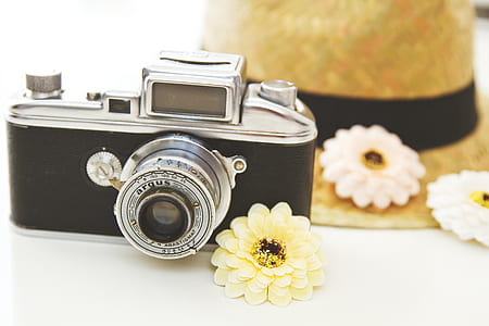 black and gray camera beside yellow petaled flower thumbnail