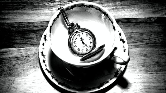 grayscale photo of pocket watch on teacup with saucer thumbnail