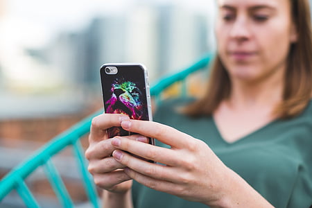 woman sitting on chair while holding iPhone thumbnail