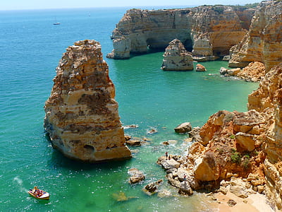 beige rock formations on body of water thumbnail
