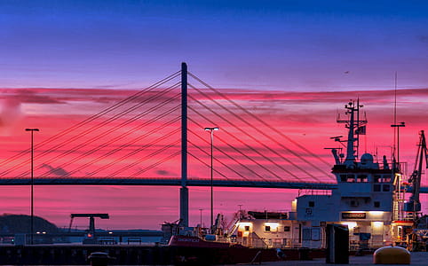 Silhouette of a Bridge Under Red Clouds and Blue Sky Taken during Night Time thumbnail