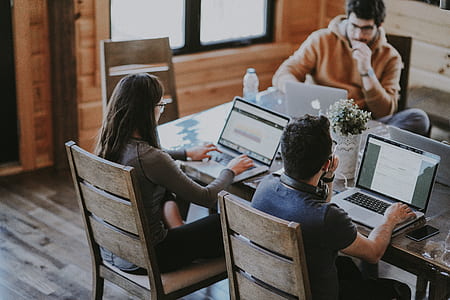 man and woman facing man sitting with laptop on table during daytime thumbnail