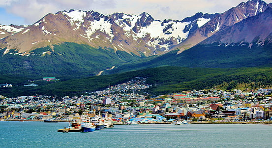photo of ship on body of water near city and mountains thumbnail