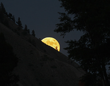 photo of hill covering half face of moon thumbnail