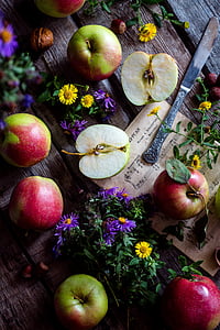 red and green apples beside flowers thumbnail