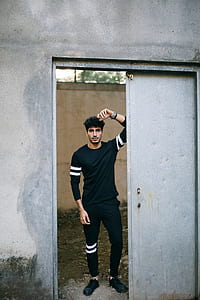 man standing in front of an open door of a building thumbnail