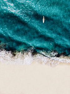 aerial photo of person riding surfboard on bodies of water thumbnail