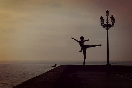 silhouette of woman perform ballerina beside street lamp thumbnail