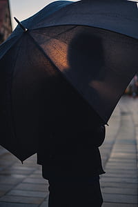 person carrying umbrella on gray sidewalk thumbnail
