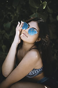 woman in blue and white bikini sitting near plants thumbnail